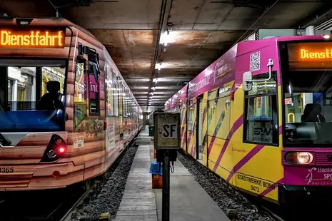 Zwei Straßenbahnen stehen nebeneinander auf Gleisen.