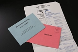 Briefwahlunterlagen bestehend aus Stimmzettel, einem roten und einem blauem Briefumschlag. © Tim Reckmann / pixelio.de