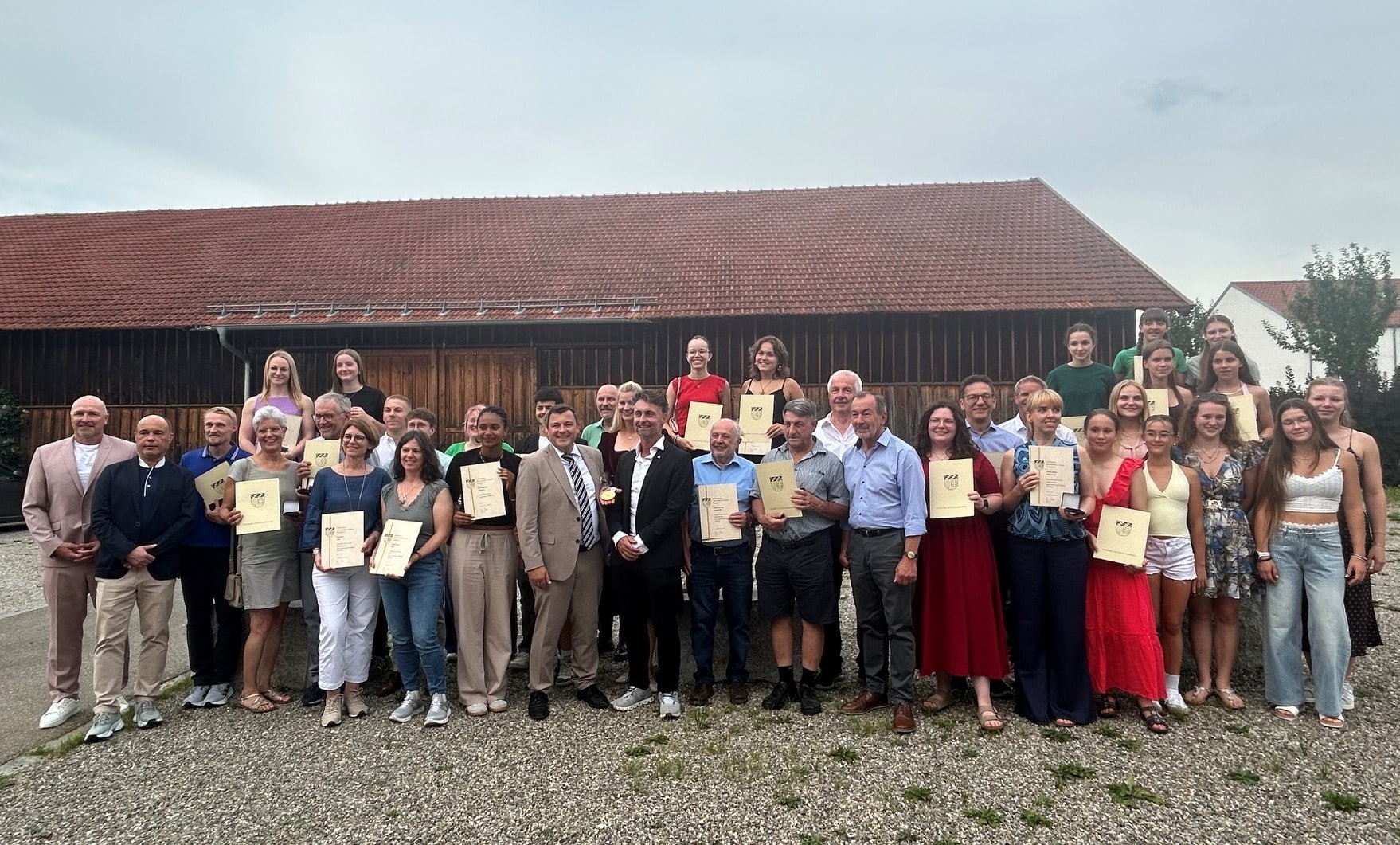 Rund 50 Personen unter freiem Himmel mit ihren Medaillen und Urkunden