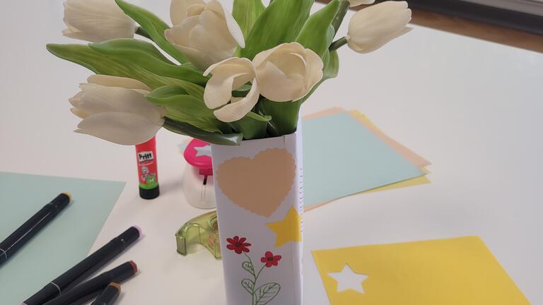 Das Bild zeigt die Blumenvase aus Milchkarton mit Blumen.