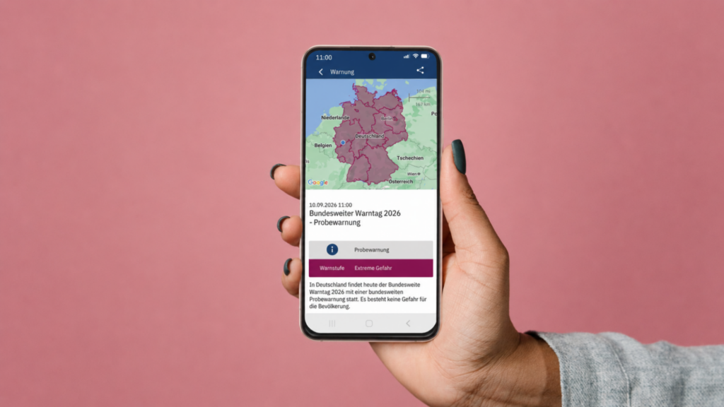 Ein Hand hält ein Smartphone hoch worauf eine Warnmeldung von NINA zu sehen ist. (c) Bundesamt für Bevölkerungsschutz und Katastrophenhilfe