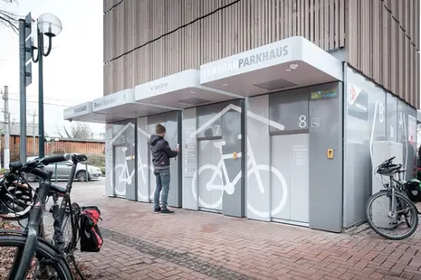 Das Foto zeigt eine Person vor einem Fahrradparkhaus