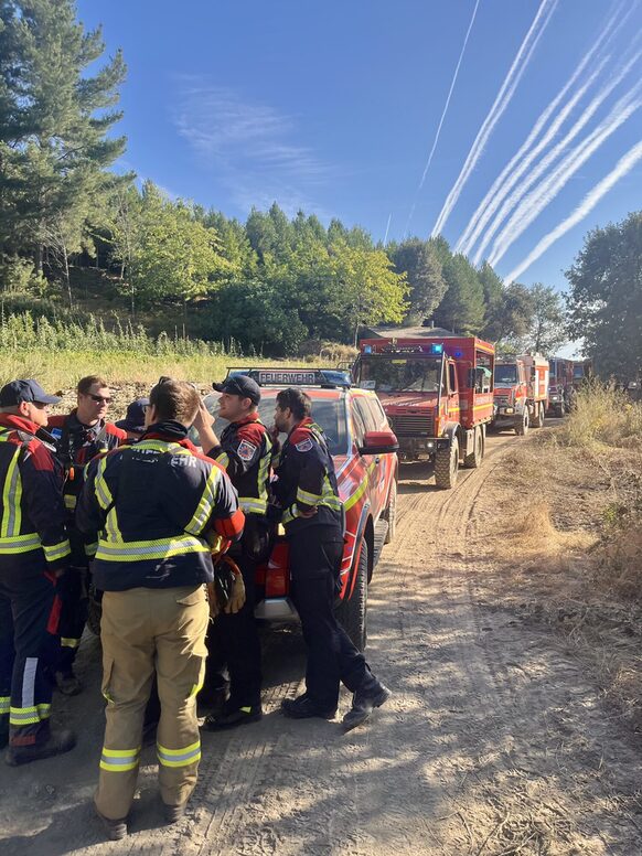 Einsatzkräfte der Brandbekämpfungskomponente bei einer Einsatzbesprechung