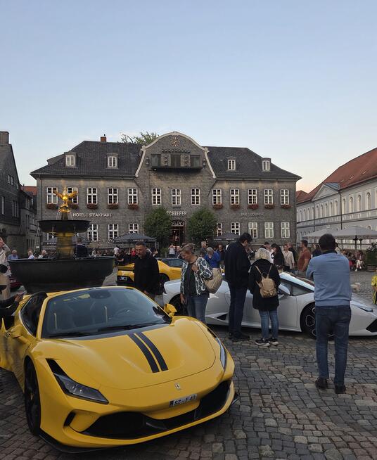 Das Bild zeigt Ferraris, die sternförmig um den Goslarer Marktbrunnen stehen und von den Gästen bestaunt werden.