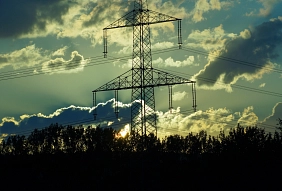 Ein Hochspannungsleitungsmast vor Wolken und der untergehenden Sonne © Renate Tröße @pixelio.de