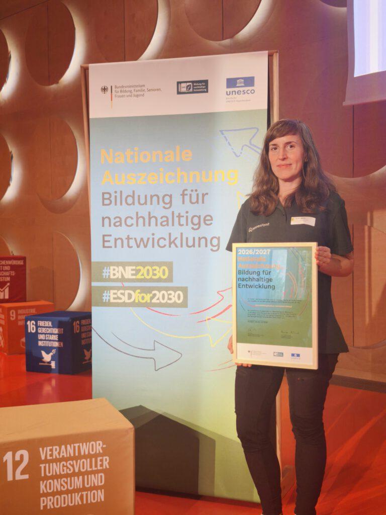 Mitarbeiterin des Hofgut Guntershausen hält Auszeichnungsurkunde in den Händen