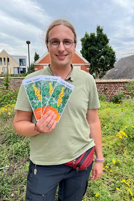 Auf dem Bild zeigt Justus Müller-Laackman den Flyer zum Abpflastern.