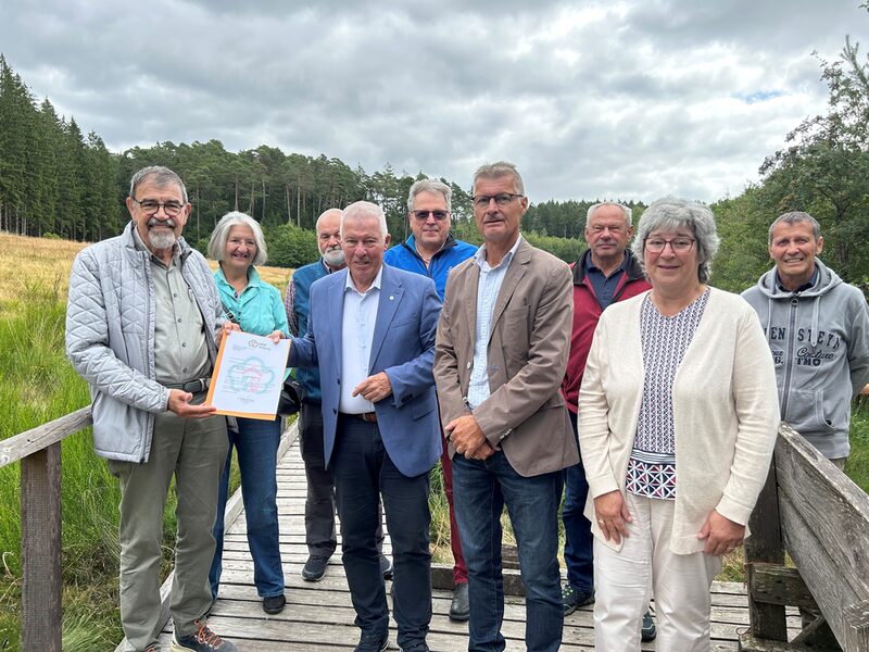Gemeinsam für das Projekt „Moorpfad“ (vorne von links):  Reinhold Müller (Eifelverein Dahlem), Prof. Dr. Karl-Heinz Erdmann (NRW-Stiftung), Bürgermeister Jan Lembach und Dahlems Ortsbürgermeisterin Marita Schramm zusammen mit Unterstützern des Eifelvereins.
