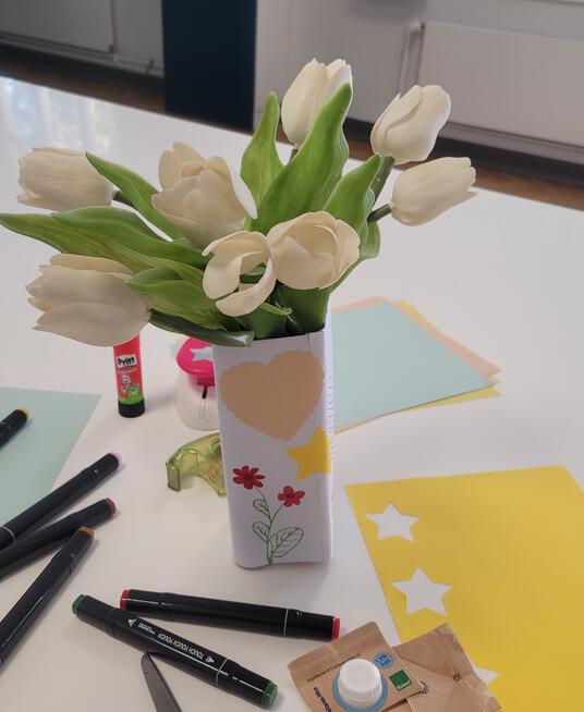 Das Bild zeigt die Blumenvase aus Milchkarton mit Blumen.
