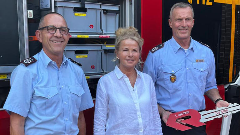 Das Bild zeigt die Genannten vor dem TLF.
