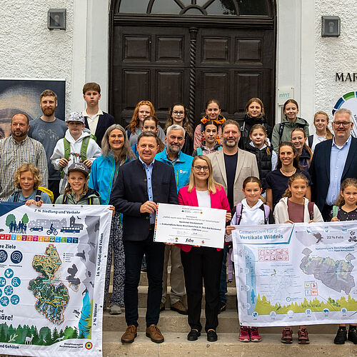 Landrat Michael Koller, Vorsitzender des Trägervereins der Biosphärenregion Berchtesgade-ner Land, und Theresia Petram vom Arbeitskreis SchuleWirtschaft (beide erste Reihe) über-reichen gemeinsam mit Dr. Peter Loreth (Leiter der Verwaltungsstelle Biosphärenregion Berchtesgadener Land) sowie Dr. Roland Baier (Leiter des Nationalparks Berchtesgaden) (beide zweite Reihe Mitte) den Gewinnscheck an die stolze Schulgemeinschaft. Die Preisgel-der zur Verfügung gestellt haben die Sparkasse Berchtesgadener Land, der Verein Freunde des Nationalparks e.V. sowie der Trägerverein Biosphärenregion Berchtesgadener Land e.V.  Foto: Maria-Ward-Realschule