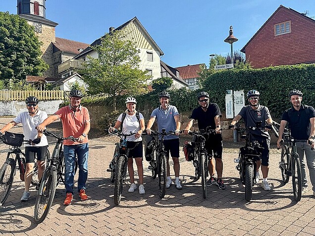 Die Bürgermeister/innen der Gemeinden Edermünde, Baunatal, Guxhagen, Körle, Fuldabrück, Willingshausen sowie Landrat Winfried Becker stehen mit ihren Fahrrädern zusammen.