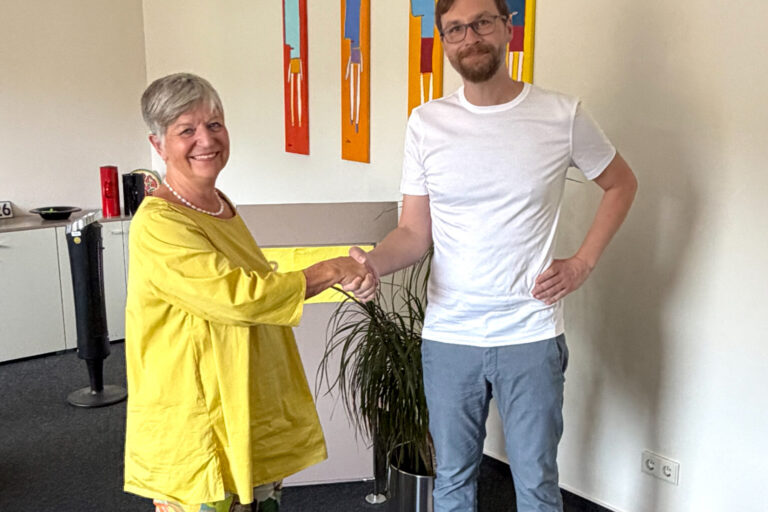 Frau und Mann stehen und schütteln sich die Hand