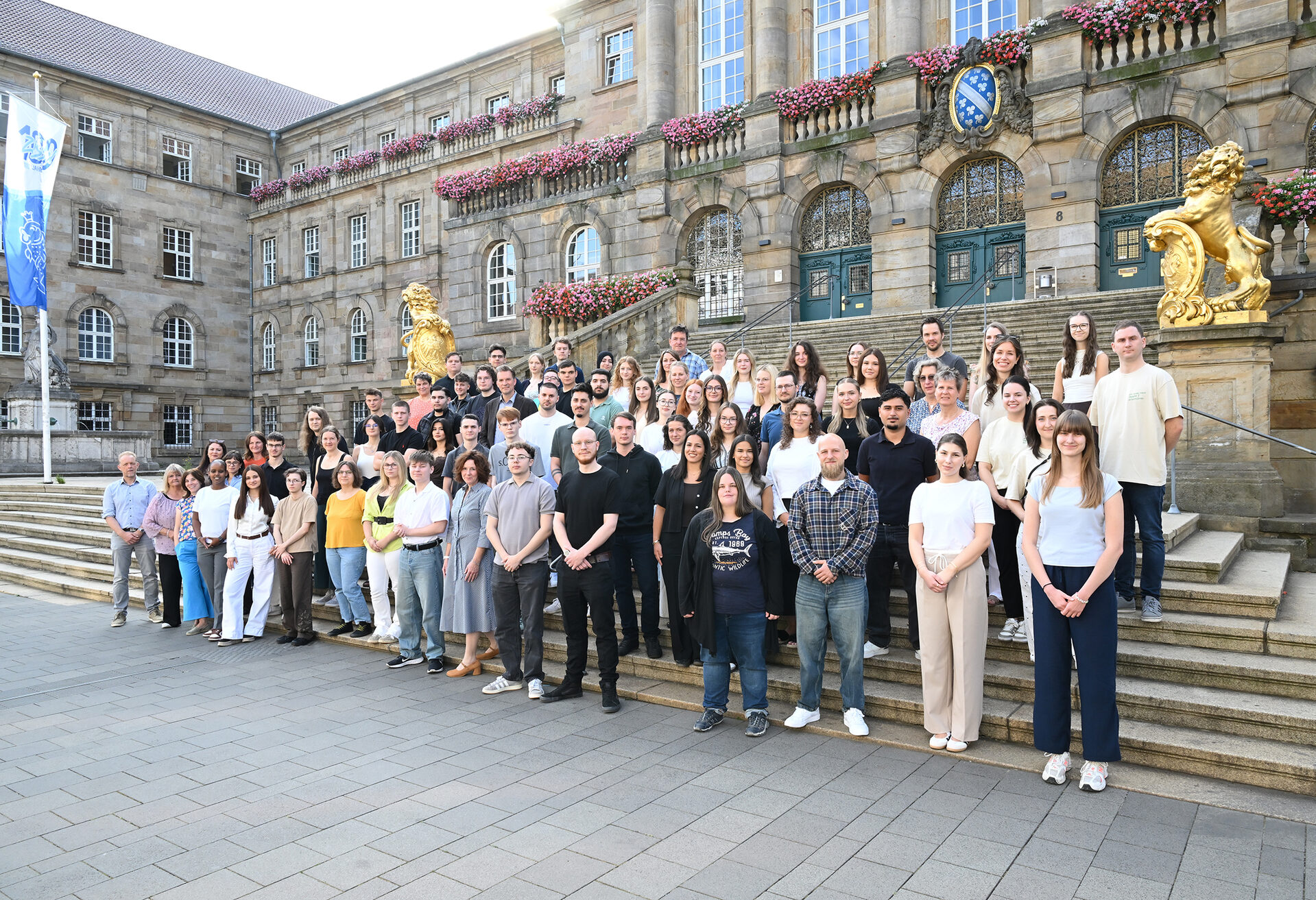 Gruppenbild der neuen Nachwuchskräfte mit Oberbürgermeister, Personalrat und Ausbildern vor dem Rathaus