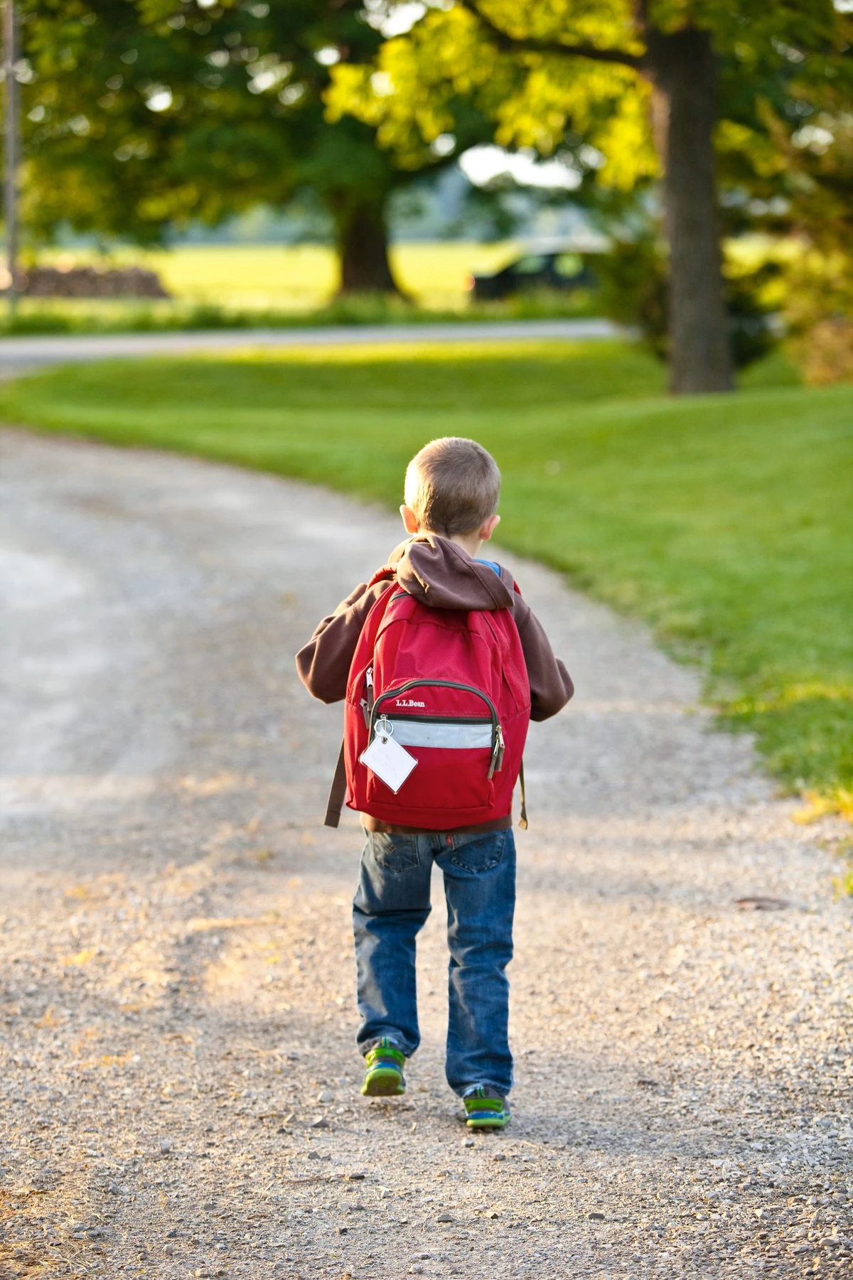 Kind von hinten mit Schulranzen