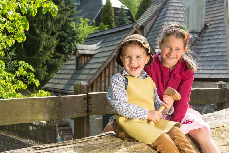 lachende Kinder sitzen auf Bank
