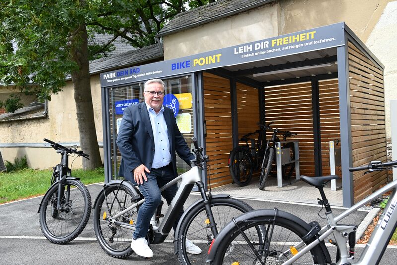 OBM Schmidt auf Fahrrad vor Verleihstation