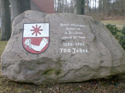 Ein Findling als Dorfstein zum 700-jährigen Dorfjubiläum. Auf dem Stein ist links das Asendorfer Wappen dargestellt, das im unteren Teil den Arm des starken Hinnerk und im oberen Teil einen roten Achtstern enthält. Auf der rechten Seite des Steins ist fol © Samtgemeinde Hanstedt