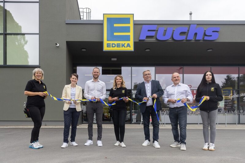 Personen mit Band vor Edeka Markt