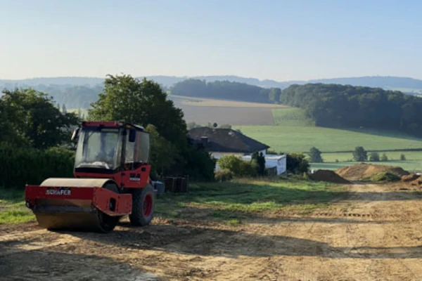 Eine Raupe steht auf dem frisch erschlossenen Bereich des Baugebiets Lupinenring