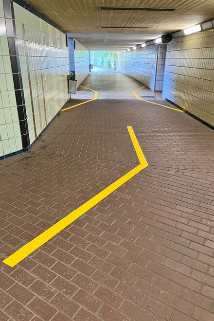 Das Bild zeigt die gelben Markierungen in der Gleisunterführung.