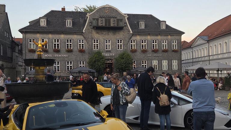 Das Bild zeigt Ferraris, die sternförmig um den Goslarer Marktbrunnen stehen und von den Gästen bestaunt werden.