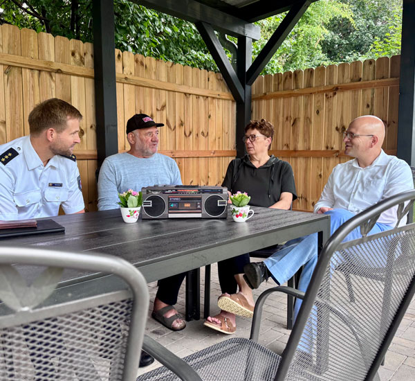 Mathias Ehrchen, Bewohner Manfred, Dietra Schwarz und Landrat Christian Müller testen die neue Aufenthaltsgelegenheit im Garten der Obdachlosenunterkunft in Groß Pankow.  Fotonachweis: Gina Werthe / Landkreis Prignitz