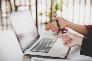 Zwei Hände zeigen auf einen Laptop-Bildschirm