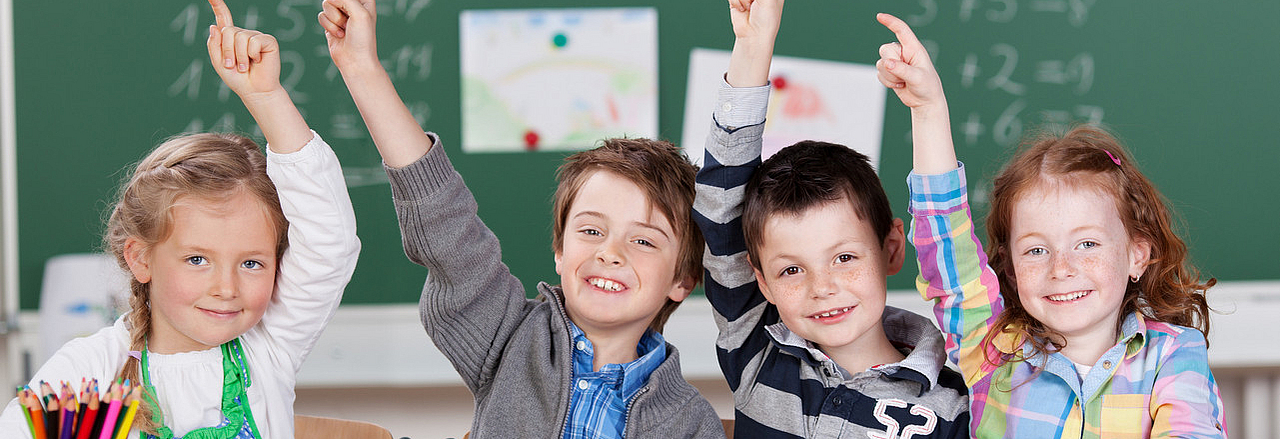 sich meldende Grundschüler im Klassenzimmer