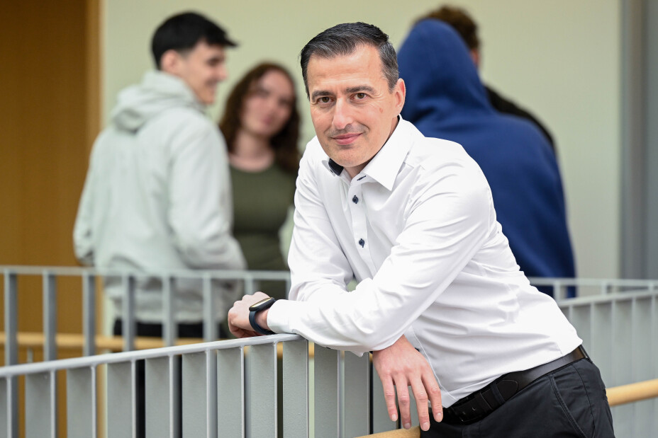 Foto: Lehrer Serhat Gökce. Im Hintergrund unscharf: Schülerinnen und Schüler.