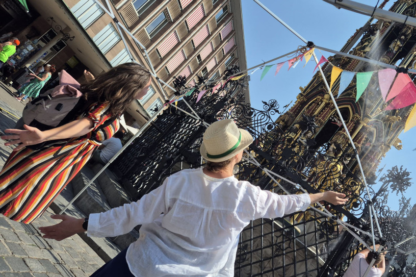 Zwei Frauen erfrischen sich an einem heißen Sommertag unter dem feinen Wassernebel am Hauptmarkt., Bild © Heike Bauer / Stadt Nürnberg