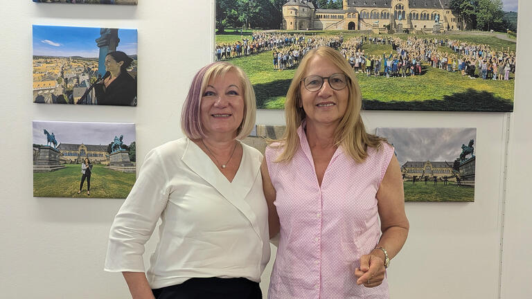Vera Tietz und Britta Rüger vor einer Wand mit Bildern.