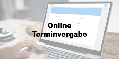 Eine Person arbeitet an einem Laptop, auf dessen Bildschirm eine Kalender- und Uhrzeitansicht zur Online-Terminvergabe angezeigt wird. In der Mitte des Bildschirms steht der Text „Online Terminvergabe“. Ein Klick auf das Bild führt zur Seite für die Online-Terminvereinbarung.