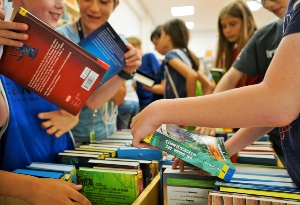 Kinder suchen sich Bücher aus einem Regal aus
