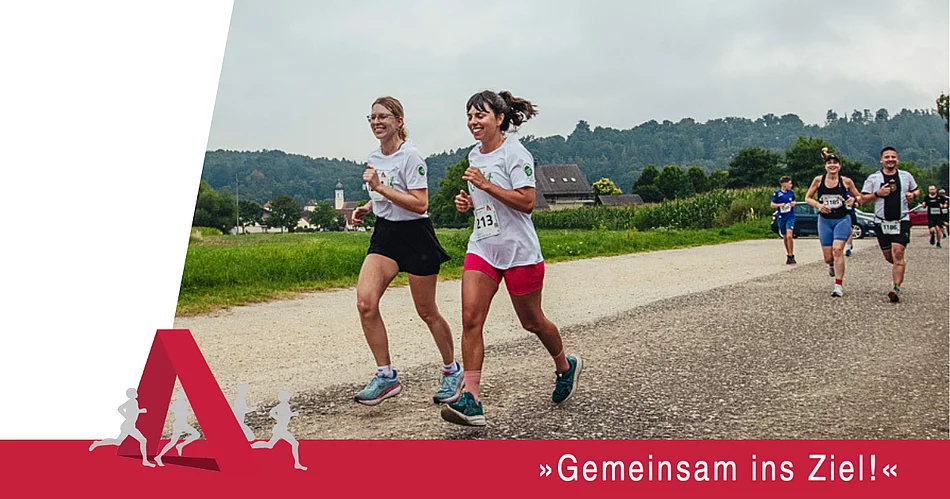 Mehrere Läuferinnen und Läufer nehmen auf einer Strecke durch die Natur am Städtedreieckslauf teil und laufen gemeinsam ihrem Ziel entgegen.