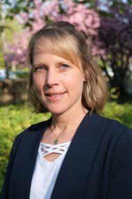 Frau vor blühenden Bäumen.