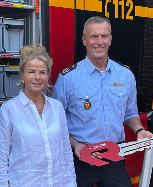 Das Bild zeigt die Genannten vor dem TLF.
